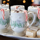 The Juliska Berry & Thread North Pole Dinnerware and Serveware Collection features festive mugs filled with hot chocolate, whipped cream, chocolate shavings, and candy canes—perfect Christmas tableware for your holiday gatherings.