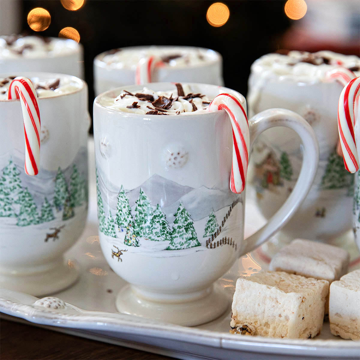 The Juliska Berry & Thread North Pole Dinnerware and Serveware Collection features festive mugs filled with hot chocolate, whipped cream, chocolate shavings, and candy canes—perfect Christmas tableware for your holiday gatherings.