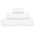 Three white towels from the Grand Egoist Bath Collection by Graccioza, crafted from luxurious Sea Island Cotton in various sizes, are stacked on a plain white background for an exclusive bath experience.