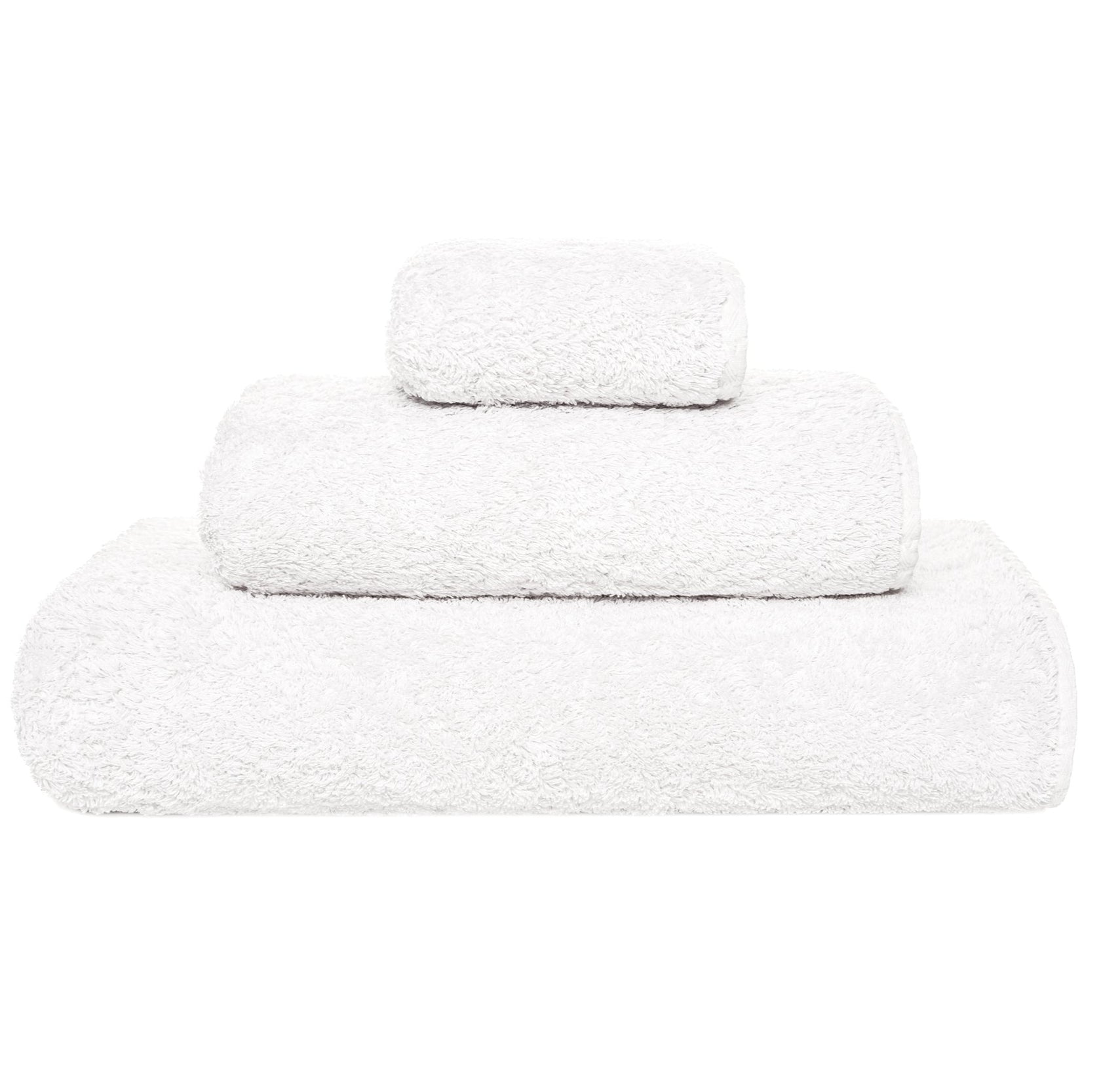 Three white towels from the Grand Egoist Bath Collection by Graccioza, crafted from luxurious Sea Island Cotton in various sizes, are stacked on a plain white background for an exclusive bath experience.