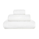 Three neatly folded white towels from the GRACCIOZA Bee Waffle Bath Collection, crafted from soft combed cotton in different sizes, are stacked atop one another against a plain white background.