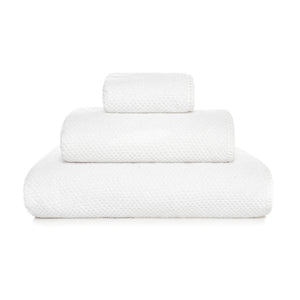 Three neatly folded white towels from the GRACCIOZA Bee Waffle Bath Collection, crafted from soft combed cotton in different sizes, are stacked atop one another against a plain white background.