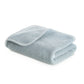 The Bee Waffle Bath Collection towel by GRACCIOZA, in light blue with a honeycomb texture, is neatly folded with one corner open, shown on a white background.