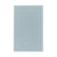 The GRACCIOZA Bee Waffle Bath Collection features a rectangular light blue combed cotton rug with a honeycomb texture and subtle double border, shown on a white background.