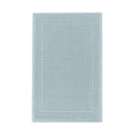 The GRACCIOZA Bee Waffle Bath Collection features a rectangular light blue combed cotton rug with a honeycomb texture and subtle double border, shown on a white background.