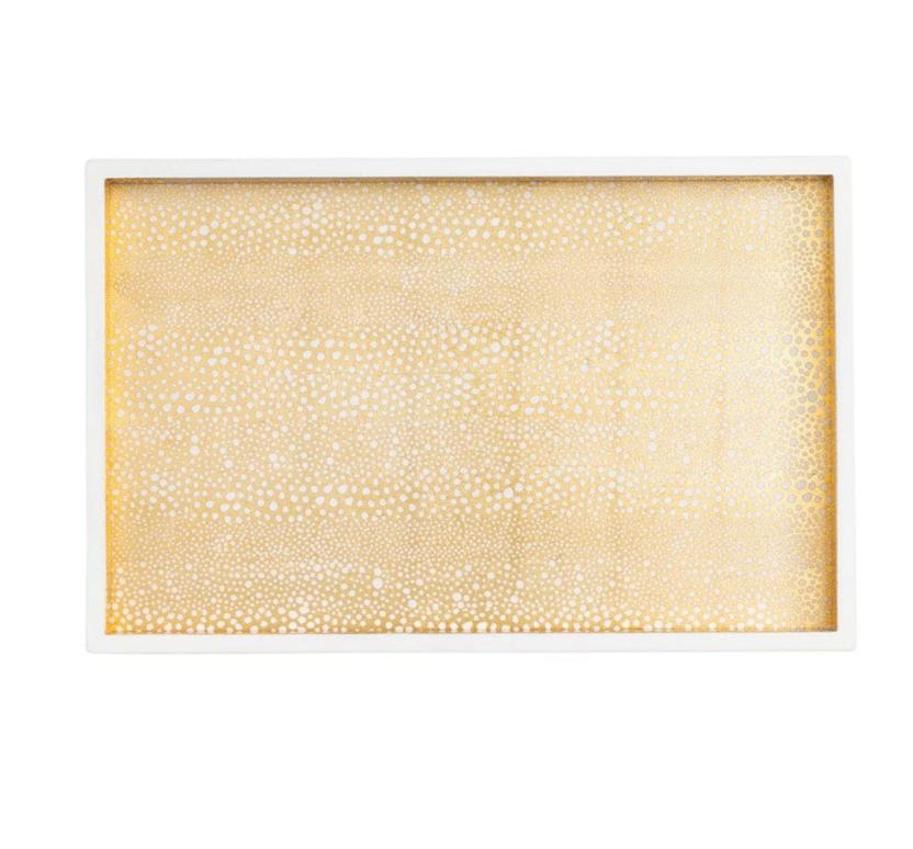 The Caspari Pebble Gold Lacquer Vanity Tray is a rectangular piece handmade in Vietnam, featuring a white border and a gold dotted pattern for a timeless accent.
