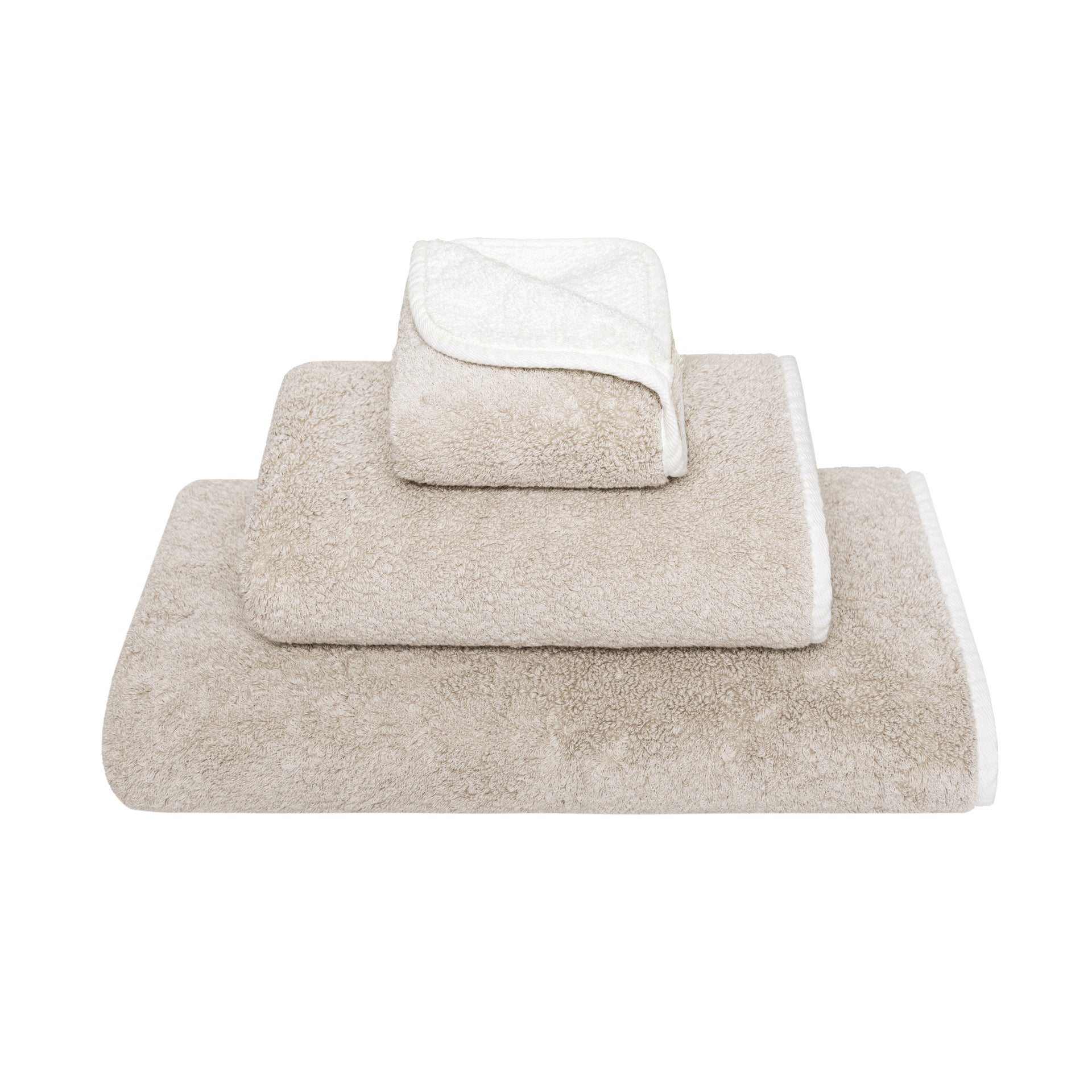 Three beige Bicolore Bath Collection towels by Gracciozza, each a different size, are stacked neatly against a white background.