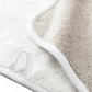 Close-up of a white and beige Graciozza Bicolore Bath Collection towel featuring a fabric hanging loop, showcasing the double-sided Egyptian cotton texture and finished edges.