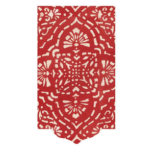 The Annika Red Collection by Caspari features a red rug with an off-white floral and geometric pattern and a scalloped edge, echoing the elegant design found on Caspari napkins.