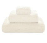 Three folded white towels from Graccioza's Pearls Bath Collection, stacked in descending size order, highlight their ultra-soft and absorbent texture against a plain white background.