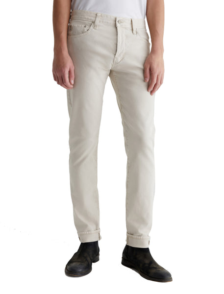 A person wearing AG Jeans Tellis Selvage, standing against a white background, visible from the waist down.