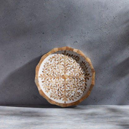 The Mya Inlay Serving and Decor Collection by Be Home features a round decorative plate with a beige and brown leaf pattern on a light gray textured surface, perfect as an elegant floral serving tray.