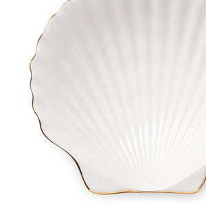 The Shell Appetizer Plate by Aerin features white ceramic in a scallop shell shape with elegant gold edging, ideal for adding coastal charm. Photographed against a white background.