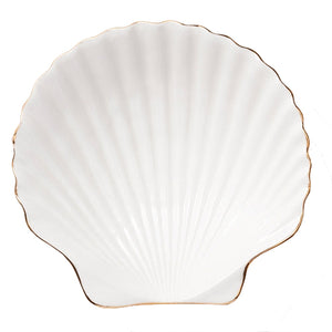 The Aerin Shell Appetizer Plate is a white ceramic plate with a scallop shell shape, ridged surface, and thin gold trim—an elegant way to bring coastal style to your table.
