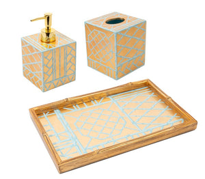 The Caspari Bamboo Screen Robin's Egg Bath Collection is a handcrafted bathroom set from Vietnam, featuring gold and blue geometric lacquerware, including a soap dispenser, tissue box cover, and rectangular tray.