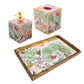 The Paradise Garden Bath Collection by Caspari is a handcrafted lacquerware set from Vietnam, featuring a soap dispenser, tissue box cover, and tray with a pink floral and butterfly pattern accented in gold.