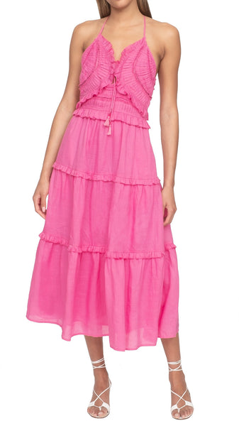 Woman wearing a pink Sea NY Cole smocked sundress with halter neck tie.
