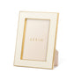 The Aerin Cream Classic Shagreen Frame Collection features a luxurious textured cream border with polished brass accents and stands upright, elegantly displaying the brand's name inside.
