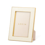 The Aerin Cream Classic Shagreen Frame Collection features a luxurious textured cream border with polished brass accents and stands upright, elegantly displaying the brand's name inside.