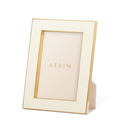 The Aerin Cream Classic Shagreen Frame Collection features a luxurious textured cream border with polished brass accents and stands upright, elegantly displaying the brand's name inside.