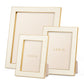 Three empty Cream Classic Shagreen frames by Aerin, in assorted sizes, are displayed upright against a white background. Polished brass accents and an elegant design highlight their luxury photo display appeal.