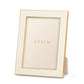 The Cream Classic Shagreen Frame Collection by Aerin features a gold-accented, embossed cream frame with a textured finish and "AERIN" on the insert—a luxurious way to display your treasured photos.