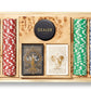The Aerin Shagreen Poker Set in Chocolate features organized stacks of colorful chips, two ornate card decks, and a dealer button—perfect for game night.