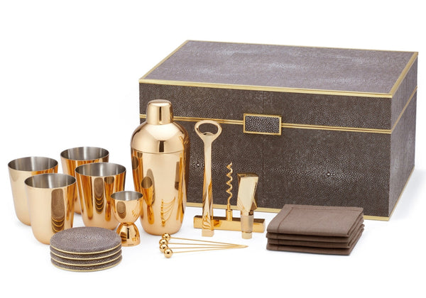 Explore the AERIN Chocolate Classic Shagreen Bar Set by Aerin, including a gold cocktail shaker, cups, bottle opener, corkscrew, coasters, stirrers, brown napkins, and a chic shagreen box—a perfect addition to elevate any home bar.