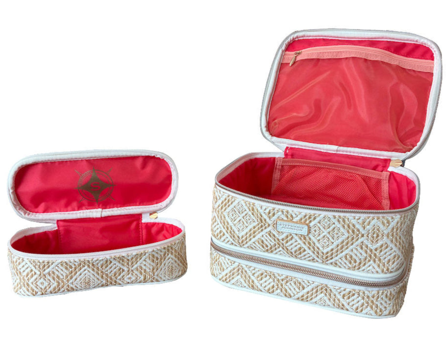Two beige and white zippered pouches from the Stephanie Johnson Paros Coconut Travel Collection, both open to show pink interiors: one is a rectangular Mae Mini Pouch, the other a smaller cylindrical Jenny Train Case.
