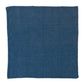 The Juliska Berry Trim Napkin Collection features a square, dark blue woven cotton napkin with a finely textured surface and delicate pom-pom trim, shown on a white background.