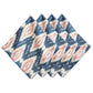The Juliska Ikat Napkin Set features four folded napkins with a blue, white, and pink geometric ikat pattern and hand-stitched trim, arranged side by side to bring island-inspired style to your table.