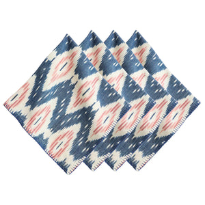 The Juliska Ikat Napkin Set features four folded napkins with a blue, white, and pink geometric ikat pattern and hand-stitched trim, arranged side by side to bring island-inspired style to your table.