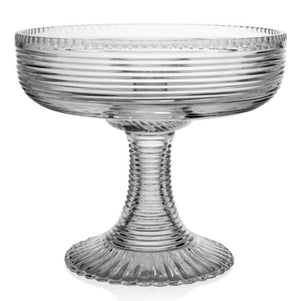 The Phoebe Centrepiece by William Yeoward Crystal is a handmade clear glass pedestal bowl with ribbed texture on the bowl and stem, displayed on a white background. California residents may receive a Proposition 65 warning.