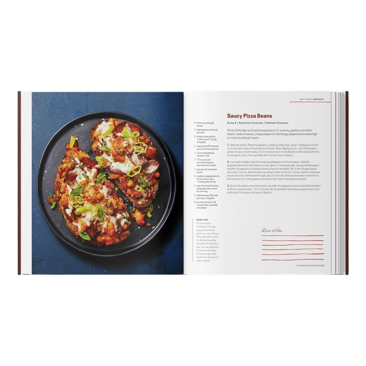 An open copy of *The Newlywed Cookbook* by Penguin Random House displays a “Saucy Pizza Beans” recipe on the right, while the left side features a plate with three cheesy, herb-topped servings—an inviting showcase of simple, shareable meals.