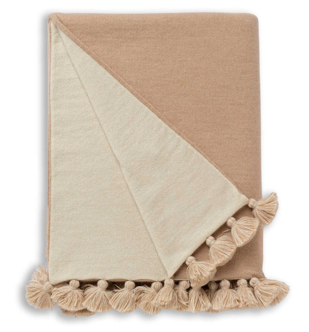 The Bali Throw in Beige/Ivory by Alicia Adams Alpaca features large tassels along the edge, displayed on a white background.
