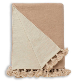The Bali Throw in Beige/Ivory by Alicia Adams Alpaca features large tassels along the edge, displayed on a white background.