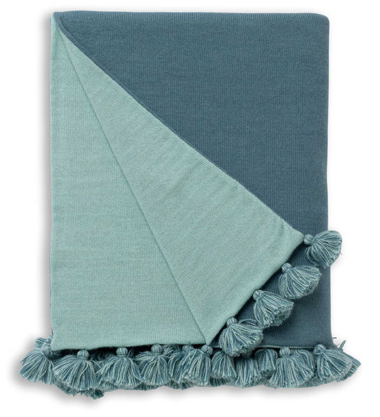 The Alicia Adams Alpaca Bali Throw in Teal/Aqua showcases a luxurious, reversible design with a folded two-toned blue and teal color scheme, crafted from soft alpaca wool and finished with decorative tassels along the edges.