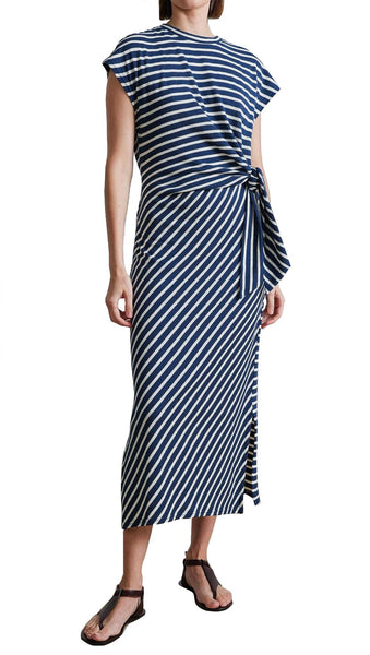 A woman wearing a Apiece Apart Vanina Cinched Waist Dress in blue and white stripes.