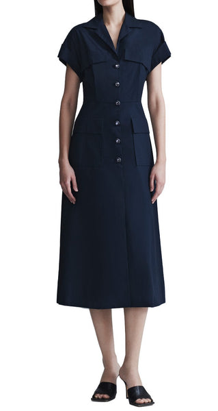 Woman wearing a navy blue Lela Rose Cotton Poplin Short Sleeve Button Down Midi Dress with short sleeves, notch collar, button-front with jewel facet buttons, and patch pockets, paired with black slide sandals. Visible against a white background.