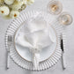 Elegant table setting featuring the Kim Seybert Arches Napkin Set, arranged with a white plate, placemat, napkin ring, silverware, two glasses, and white flowers atop a light gray surface.