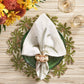 A green glass plate with a white napkin and beaded palm tree napkin ring rests on a Kim Seybert Oasis Placemat, perfect for tropical entertaining, alongside two glasses and a nearby floral arrangement.