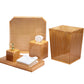 The Kim Seybert Natural Reed Bath Collection features gold-colored bathroom accessories with a natural wicker cane design, including a pump dispenser tray, towels, tissue box cover, wastebasket, and a raised-edge tray for stylish decor.
