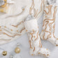Two white Gilt Wave stockings and a matching tree skirt, all decorated with swirling gold and silver beading and clear crystals for elegant holiday décor.