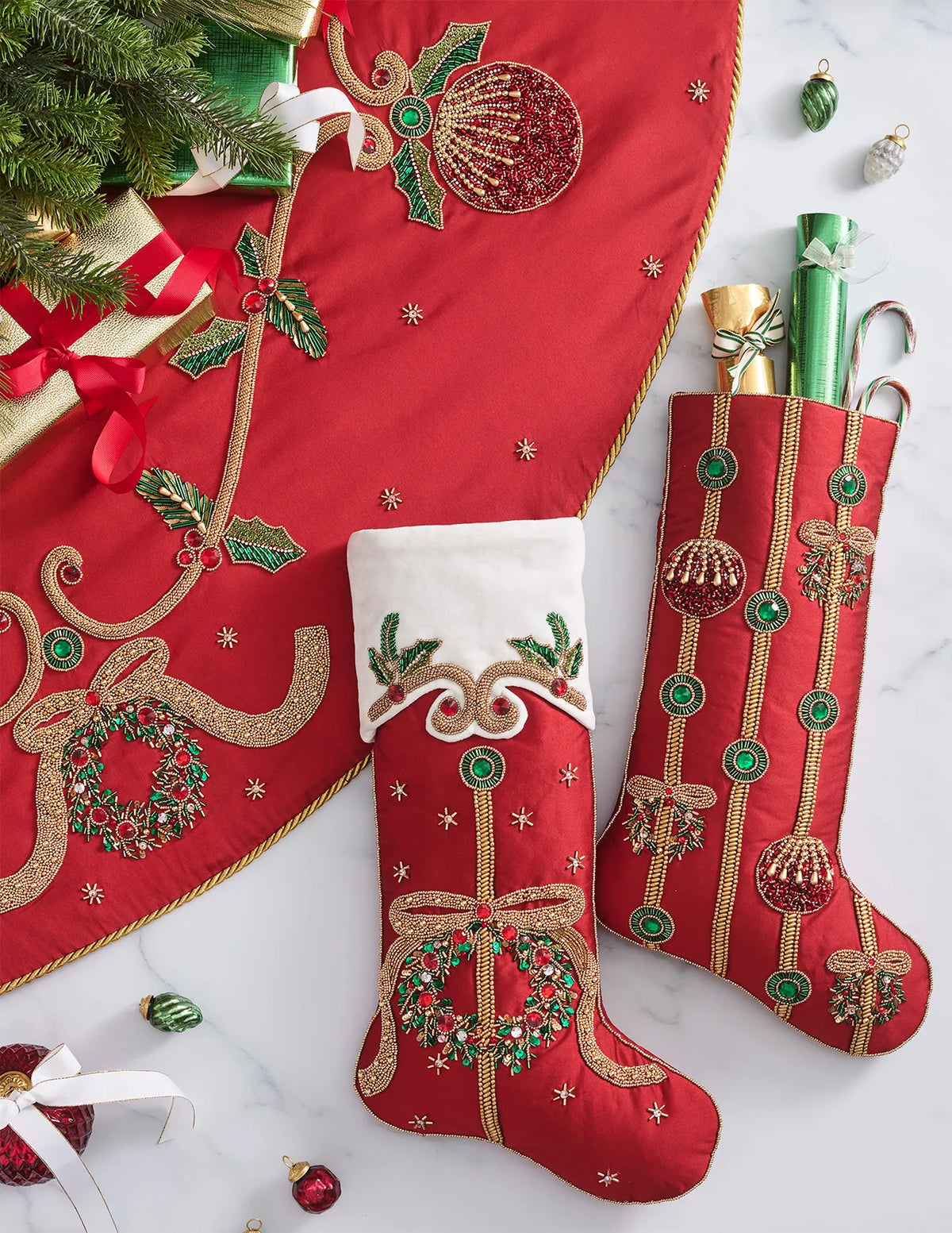 A Jewel Garland Tree Skirt and two stockings decorated with beaded embroidery of Christmas wreaths, ornaments, and holly leaves.