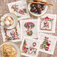 Six Kim Seybert Santa Cocktail Napkins with embroidered festive scenes of Santa Claus, arranged on a wood-grain table with plates of cookies and a mug of hot cocoa.