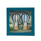 The L'Amour Toujours Hot Air Balloon Salt and Pepper Shaker Set by Juliska features hand-painted blue and white ceramic shakers in a teal Juliska gift box with a scenic background illustration.