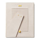The Colette Cane Frame by AERIN is a beige rectangular picture frame with a cane-textured surface, gold accents, and "AERIN" on a gold plate at the top. The stand is extended.
