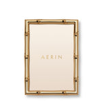 The Ava Bamboo Frame Collection by Aerin features a rectangular gold-finish frame with a bamboo-style design and a blank insert displaying "AERIN" at the center.