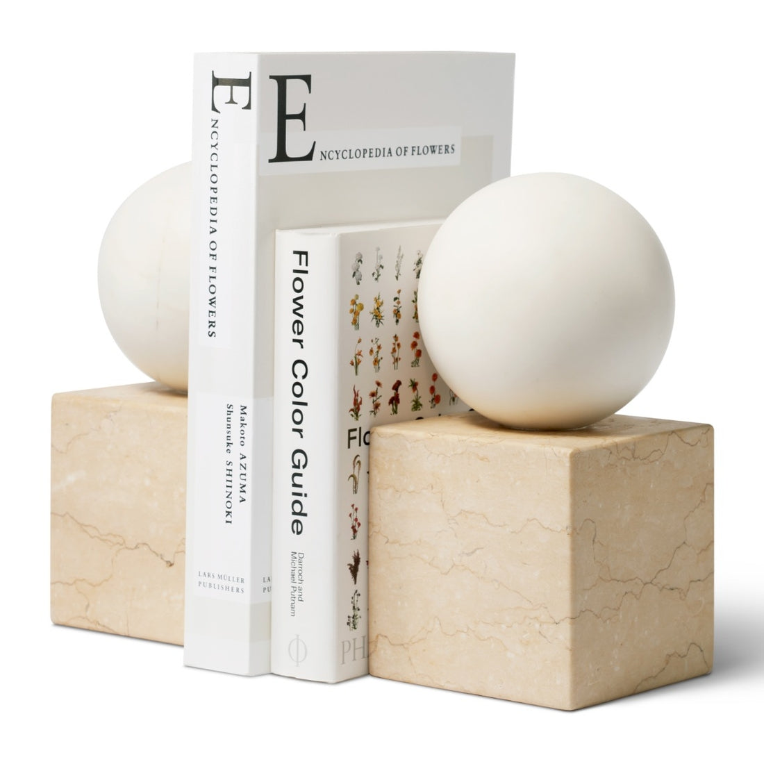 The Odette Bookend Set by Aerin features two marble bookends topped with smooth white spheres, creating a striking example of geometric design inspired by modernist sculpture.