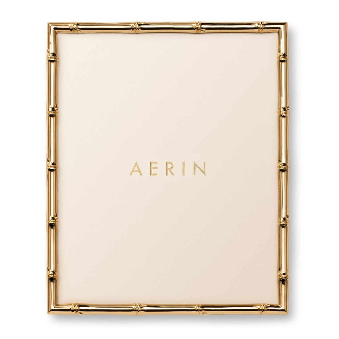 Aerin's Ava Bamboo Frame Collection features a gold-finished, bamboo-style rectangular photo frame with a cream background and the brand name "AERIN" in gold letters at the center.